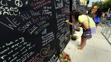 Samantha Lepore, estudiante de la Universidad de California Santa Barbara (UCSB), escribe en un muro en recordación de las víctimas en la masacre.