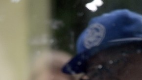 La imagen de un estudiante es reflejada en la vidriera del Isla Vista Deli Mart perforada por los disparos.