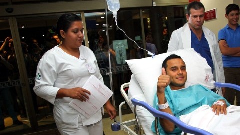 Luis Montes es llevado a su cuarto tras ser operado en Guadalajara; en el recuadro, compañeros de Javier Aquino lo felicitan en Shanghai.