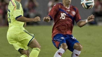 El costarricense Christian Gamboa trata de controla el balón ante la llegada del japonés Shinji Kagawa en el partido amistoso de ayer.