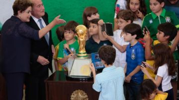La presidenta de Brasil, Dilma Rousseff (izq.),  presenta a  unos niños a Joseph Blatter, luego de recibir el trofeo de la Copa.
