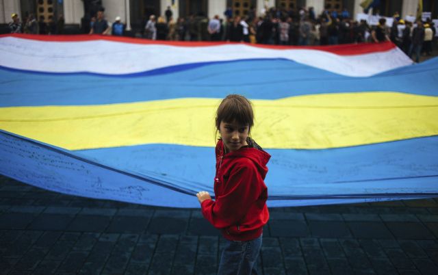 Una niña refugiada juega con una bandera ucraniana. Más de 10,000 personas han abandonado sus hogares desde el comienzo de la crisis ucraniana.