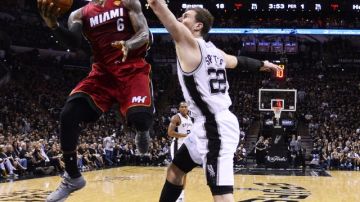 Tiago Splitter, de los Spurs (der.),  intenta bloquear a LeBron James, del Heat,  durante el primer juego de las Finales de la NBA.