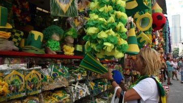 Una turista  busca en un mercado popular de  de Río de Janeiro  productos relacionados con la Copa del Mundo que ha causado una explosión en los precios de bienes y servicios.