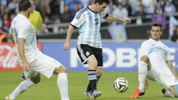 Lionel Messi trata de controlar el balón ante la marca de los eslovenos Eric Salkic (izq.) y Miral Samardzic (der.) en el amistoso de ayer.