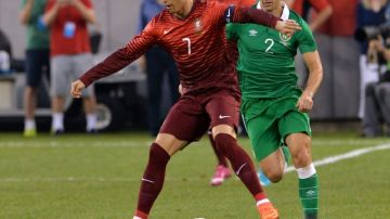 Cristiano Ronaldo (izq.) controla el balón ante  la marca del irlandés  Stephen Kelly  en amistoso celebrado en el Estadio Metlife.