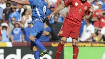 Javi Martínez, de España, rechaza el balón con la cabeza ante el acoso del jugador de El Salvador, Rafael Burgos.