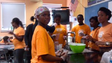 Jennifer Rosario, trabajadora social de Partnership With Children, enseña a estudiantes del Sur de El Bronx a preparar malteadas como parte del programa Summer Quest.