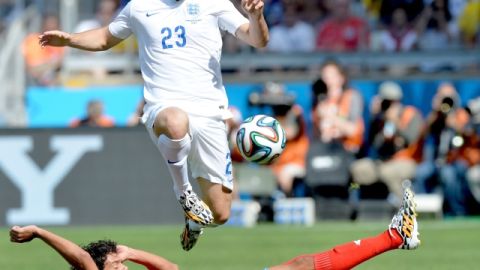 Yeltsin Tejeda, de Costa Rica, se barre para tratar de quitarle el balon a  Luke Shaw en el partido de ayer.