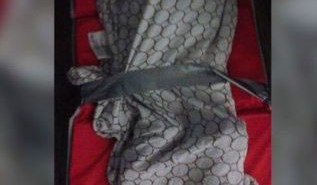 La foto, suministrada por una de las madres, muestra a un niño encintado a su manta para dormir.