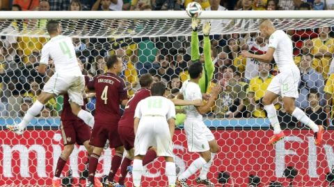 Islam Slimani (der.) remata de cabeza para anotar el gol que le dio a Argelia el empate contra Rusia en Curitiba.