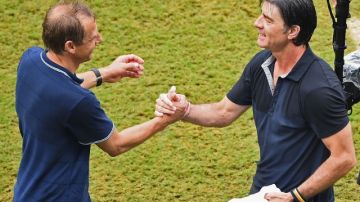 Jurgen Klinsmann (izq.) y Joachim Loew se saludan tras la culminación del encuentro ganado por Alemania.