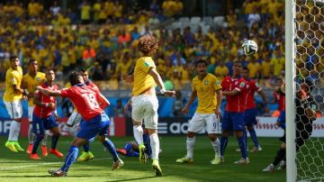 Davixd Luiz of Brazil scores his team's first goal past  goalkeeper Claudio Bravo of Chile during the 2014 FIFA World Cup Brazil.