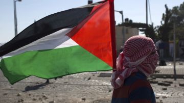 Un joven ondea una bandera palestina durante un enfrentamiento contra las fuerzas israelíes en el barrio de Shuafat.