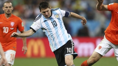 Lionel Messi (izq.) y el holandés Ron Vlaar disputan el balón, ayer en la Arena Sao Paulo.