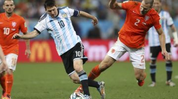 Lionel Messi (izq.) y el holandés Ron Vlaar disputan el balón, ayer en la Arena Sao Paulo.