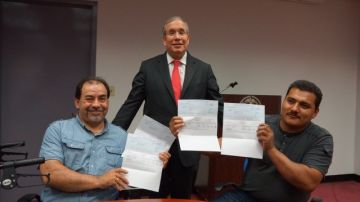 El contralor Scott Stringer dio ayer los cheques con los salarios impagados y debidos a los trabajadores Angel Ribadeneira (izquierda) y Francisco Ayala  (derecha).