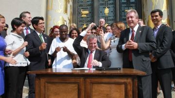 De Blasio firmó la ley del ID municipal en presencia de la presidenta del Concejo Melissa Mark–Viverito y otros oficiales elegidos.