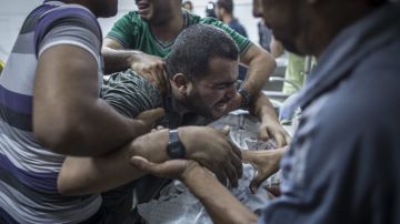 Un hombre palestino llora sobre el cadáver de su hijo tras su muerte en el depósito del hospital de Shifa, en Gaza, el jueves, 17 de julio.
