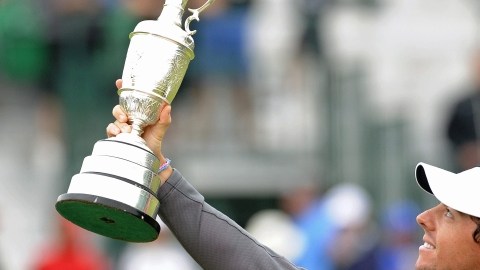 Rory McIlroy levanta el trofeo que lo distingue como el ganador del Abierto Británico.
