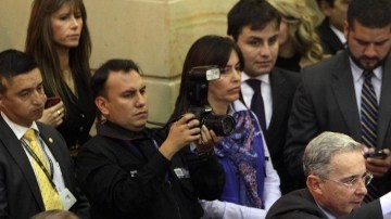El ex presidente y actual senador Álvaro Uribe (centro) saluda tras ingresar al Congreso de Colombia ayer en la instalación del período legislativo.