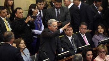 El ex presidente y actual senador Álvaro Uribe (centro) saluda tras ingresar al Congreso de Colombia ayer en la instalación del período legislativo.