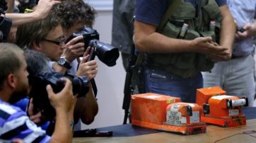 Periodistas toman imágenes de las dos cajas negras del vuelo MH17 de Malaysian Airlines antes de ser entregadas por separatistas prorrusos.