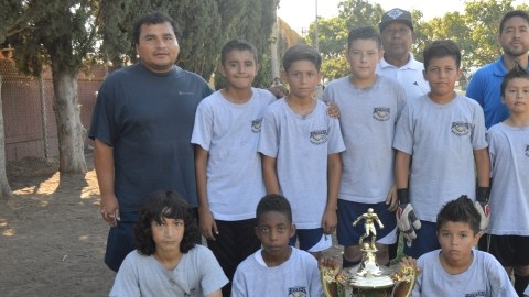 Eagles Holyfield con su DT, Salvador García (al fondo a la derecha), son uno de los equipos más destacados de la Liga Juvenil.