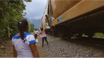 Las mujeres preparan comidas y se las arrojan a los migrantes cuando va pasando el tren.