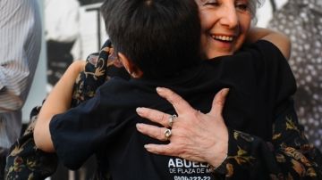 Estela de Carlotto, presidenta a grupo  Abuelas de Plaza de Mayo, abraza a un niño durante el 38 aniversario del golpe militar en su país.