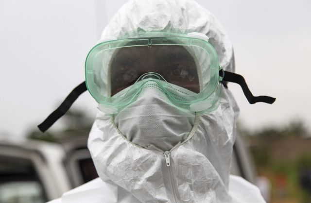 Un enfermero liberiano viste su equipo para manipular el cadáver de una persona que murió a causa del ébola.