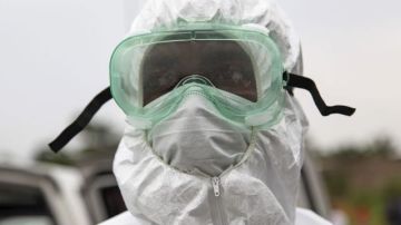 Un enfermero liberiano viste su equipo para manipular el cadáver de una persona que murió a causa del ébola.