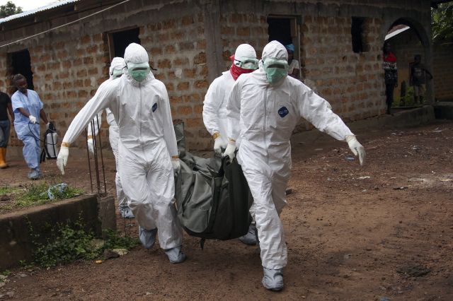Enfermeros liberianos trasladan el cuerpo de una víctima del ébola para su entierro en la comunidad de Banjor, a las afueras de Monrovia.