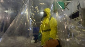 Personal militar viste con trajes especiales mientras trabajan en la simulación de un caso de enfermo de un virus contagioso en República Checa.
