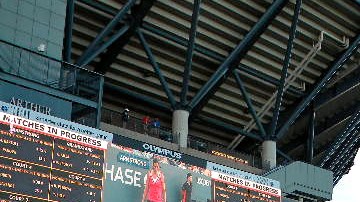 Fans ansiosos esperan entrar al imponente Arthur Ashe Stadium.