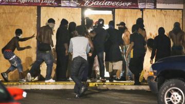 Las protestas en Ferguson crecieron el viernes después que la policía identificó al oficial que disparó contra Michael Brown.