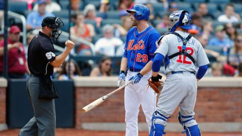 Eric Campbell discute un ponche mientras John Baker observa la decisión del umpire.