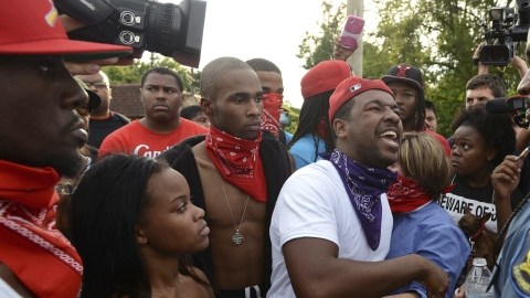 El capitán Ron Johnson (der.), de la Policía de Missouri, escucha protestas sobre la muerte de Michael Brown en Ferguson.