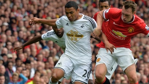 Jefferson Montero (izq.),  del Swansea, intenta pasar  frente a la marcación de Phil Jones en un trámite del partido disputado ayer en el estadio Old Trafford de Manchester.