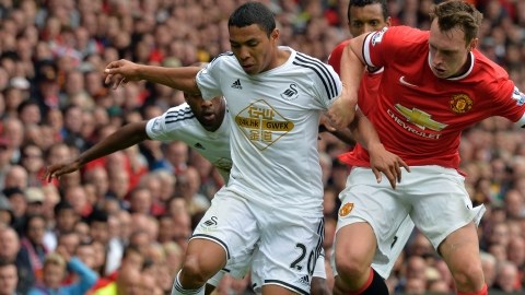 Jefferson Montero (izq.),  del Swansea, intenta pasar  frente a la marcación de Phil Jones en un trámite del partido disputado ayer en el estadio Old Trafford de Manchester.