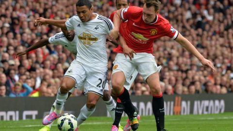 Jefferson Montero (izq.),  del Swansea, intenta pasar  frente a la marcación de Phil Jones en un trámite del partido disputado ayer en el estadio Old Trafford de Manchester.