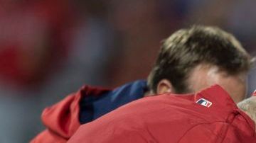 Garret Richards recibe asistencia médica tras la lesión en la rodilla que sufrió en el segundo inning.