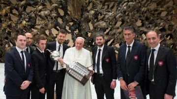 El Papa Francisco, junto a la comitiva de San Lorenzo, carga la Copa Libertadores que ganó el equipo de sus amores.