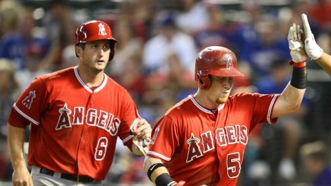 David Freese (6) y Albert Pujols (5) felicitan a  Kole Calhoun (c), que conectó jonrón de tres carreras para los Angelinos contra los Rangers en Arlington, Texas.