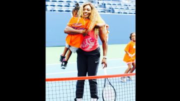 Serena Williams abraza a una niña durante la clínica.