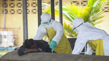 Enfermeras tratan de ayudar a una persona contagiada con el virus del ébola en Liberia.