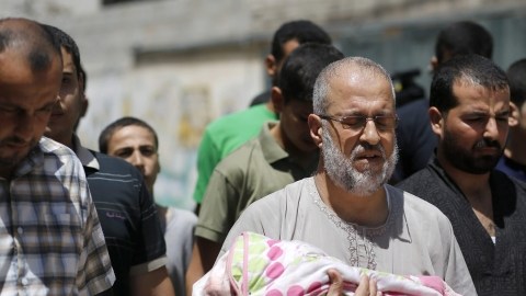 Un hombre carga a su nieta de 18 meses,  Zainah Abu-Taqeia, quien murió tras un ataque aéreo de Israel.