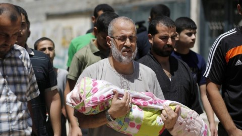 Un hombre carga a su nieta de 18 meses, Zainah Abu-Taqeia, quien murió tras un ataque aéreo de Israel.