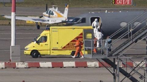 Personal médico vestido con trajes especiales abandonan un avión Gulfstream en el aeropuerto de Hamburgo, en preparación para recibir a un paciente infectado con ébola.