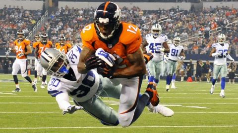 Andre Caldwell de los Broncos atrapa un pase ante Terrance Mitchell de los Cowboys en el estadio de AT&T en Arlington, Texas.